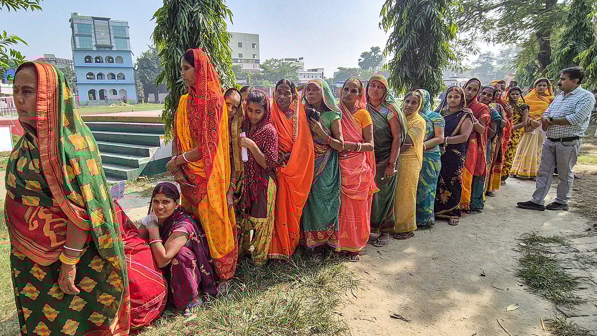 Women wait to vote at a polling station in Hajipur, 6 Nov