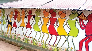 Applying a fresh coat of mud on the walls every year is mostly done by women in a Santal family