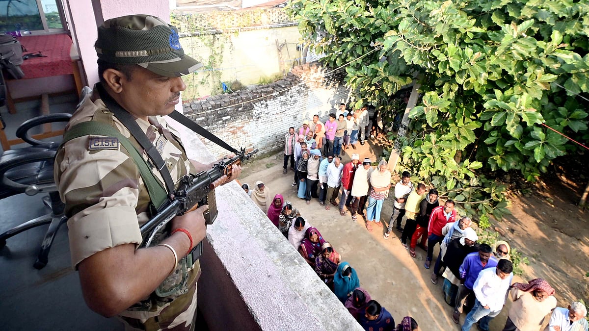 Security personnel stand guard at a polling booth in Jehanabad during the final phase of Bihar polls.