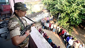 Security personnel stand guard at a polling booth in Jehanabad during the final phase of Bihar polls.