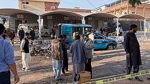Security officials examine a vehicle at the site following a outside the gates of a court.