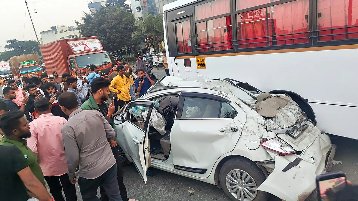 Onlookers watch the mangled car remains on the Mumbai–Bengaluru Highway in Pune.