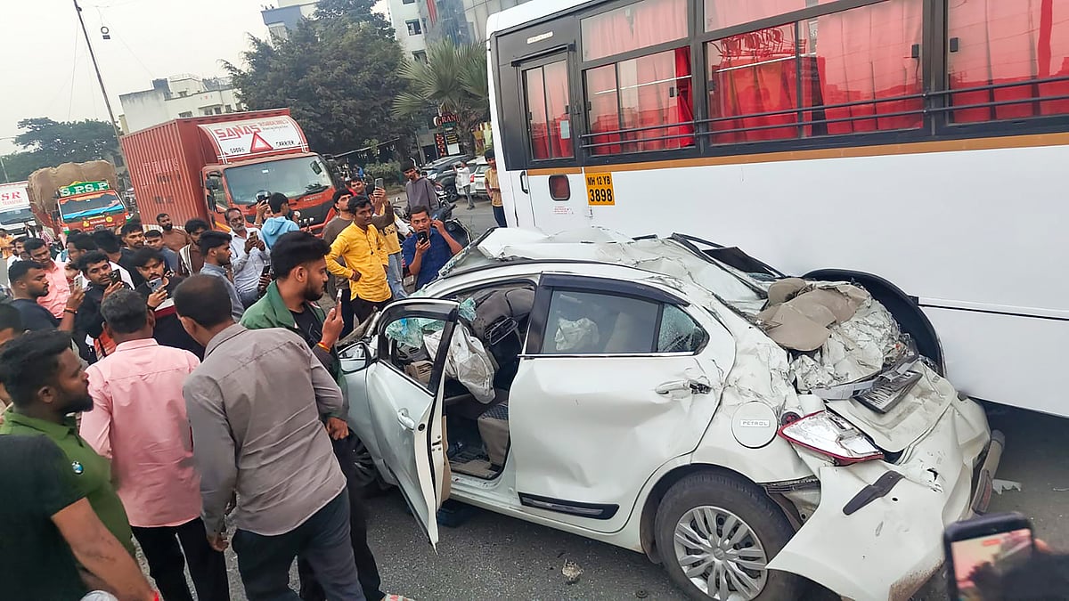 Onlookers watch the mangled car remains on the Mumbai–Bengaluru Highway in Pune.
