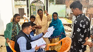A BLO explains details of enumeration forms to voters for the SIR in Mirzapur, Uttar Pradesh