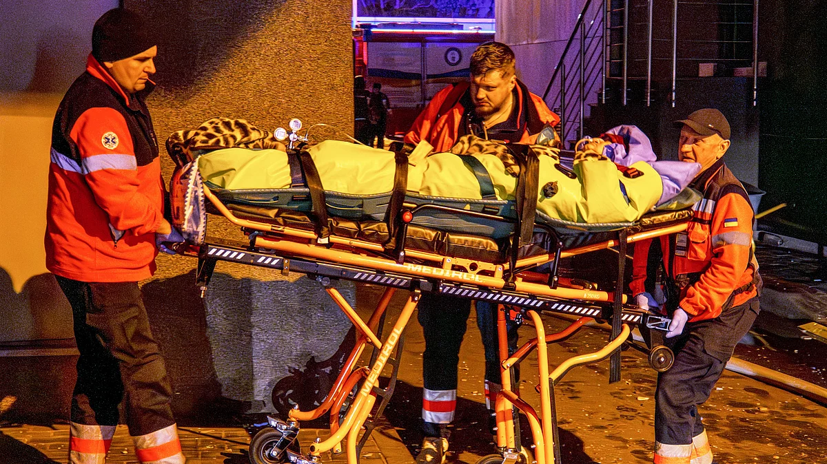 Rescue workers carry a person from a residential building following a Russian attack in Kyiv, 25 Nov