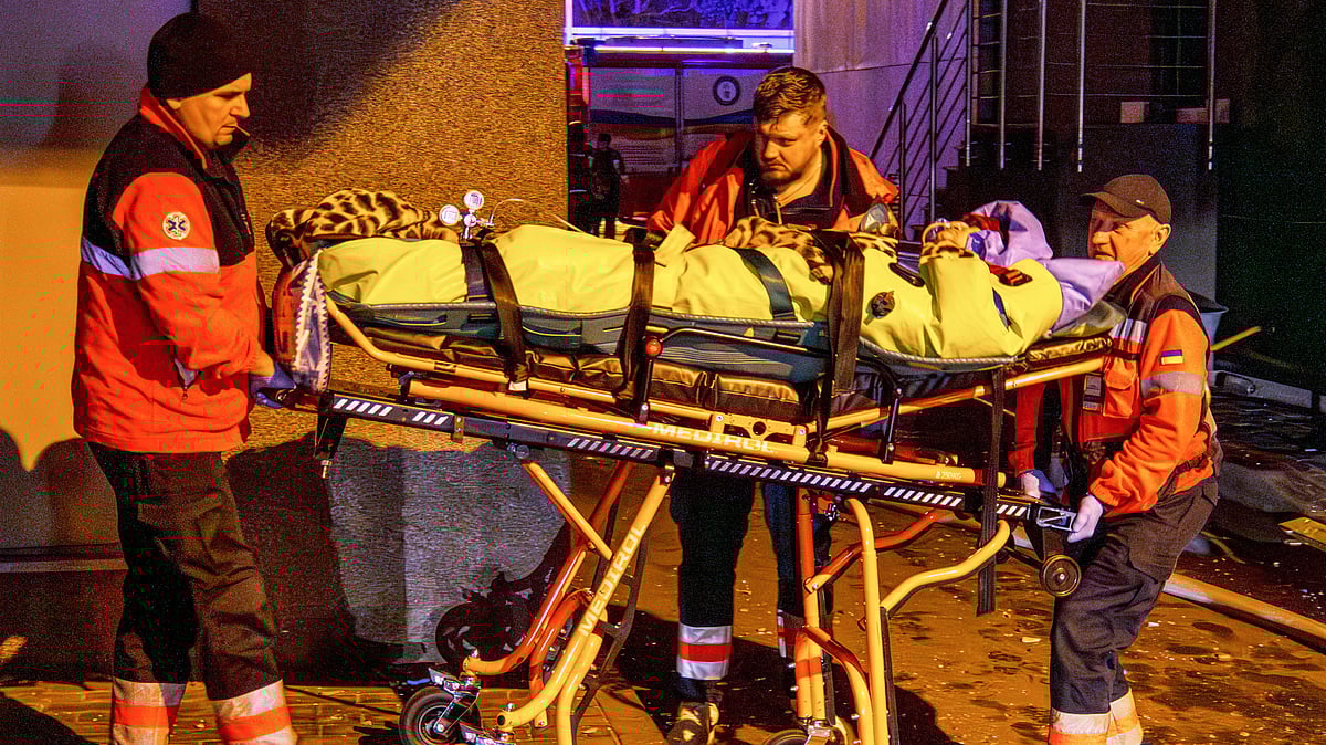 Rescue workers carry a person from a residential building following a Russian attack in Kyiv, 25 Nov