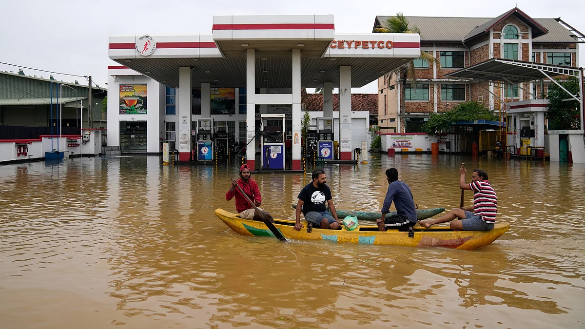People use a boat to navigate a flooded street in Colombo.