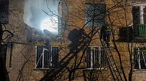 Firefighters douse flames after a drone strike hits a residential building in Kyiv.