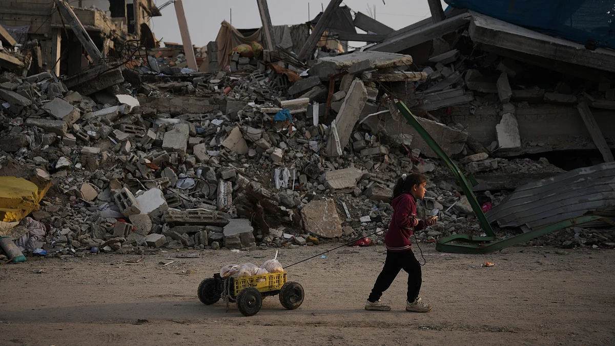 A girl carries bread past rubble from Israeli strikes in Gaza City.