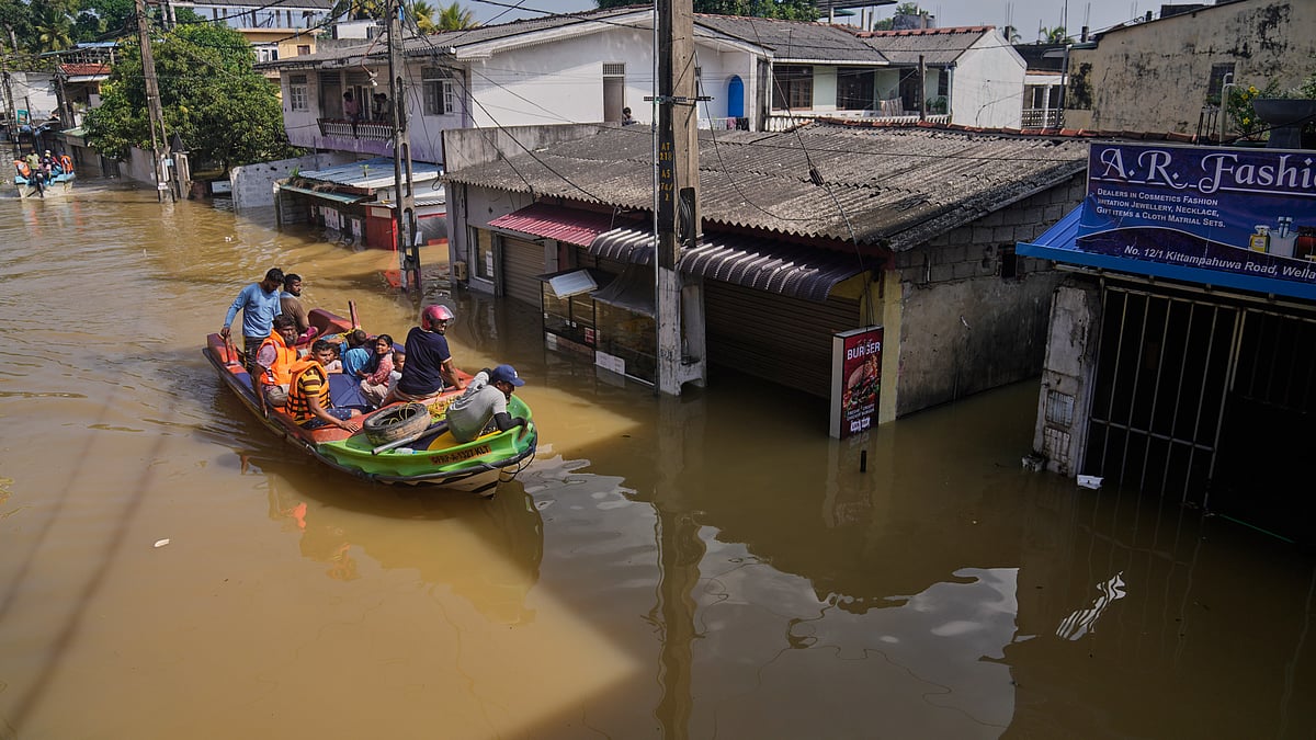 Rescuers move people to safety in a submerged area of Colombo.
