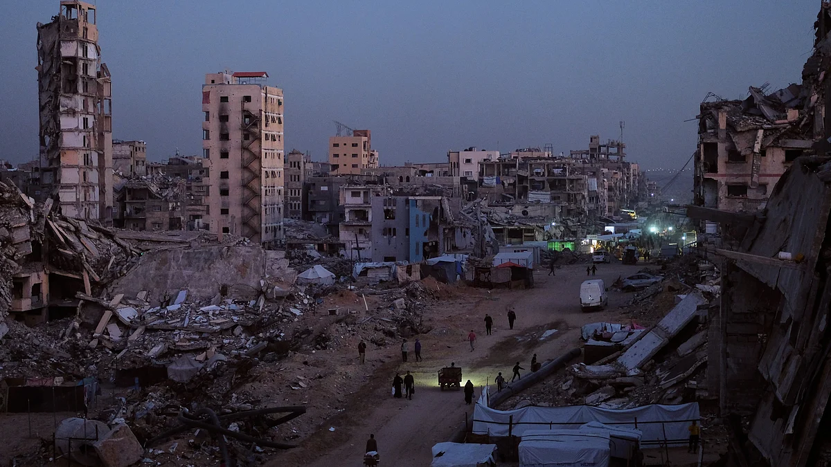 Palestinians navigate the rubble-strewn streets of Al-Karama in Gaza City.