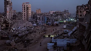Palestinians pick their way through the wreckage of Al-Karama in Gaza City.