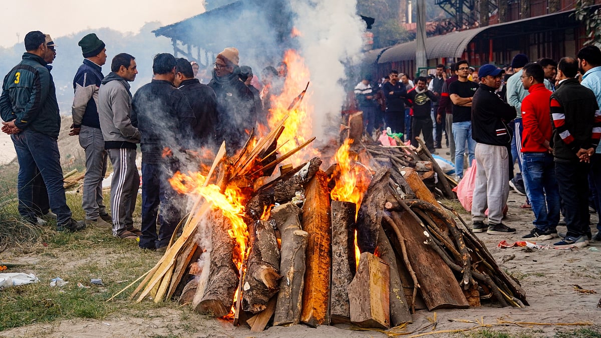 Relatives at the funeral pyres of victims of the nightclub fire, in New Delhi