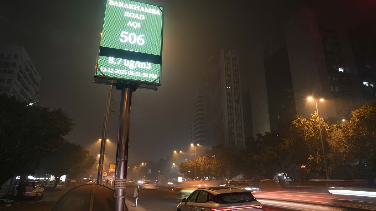 Vehicles pass an AQI monitor showing 506 on Barakhamba Road, New Delhi.