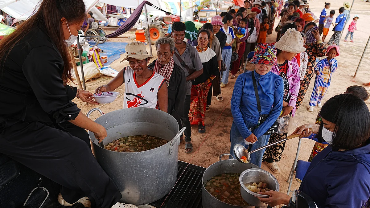 Displaced civilians queue for soup in Cambodia.