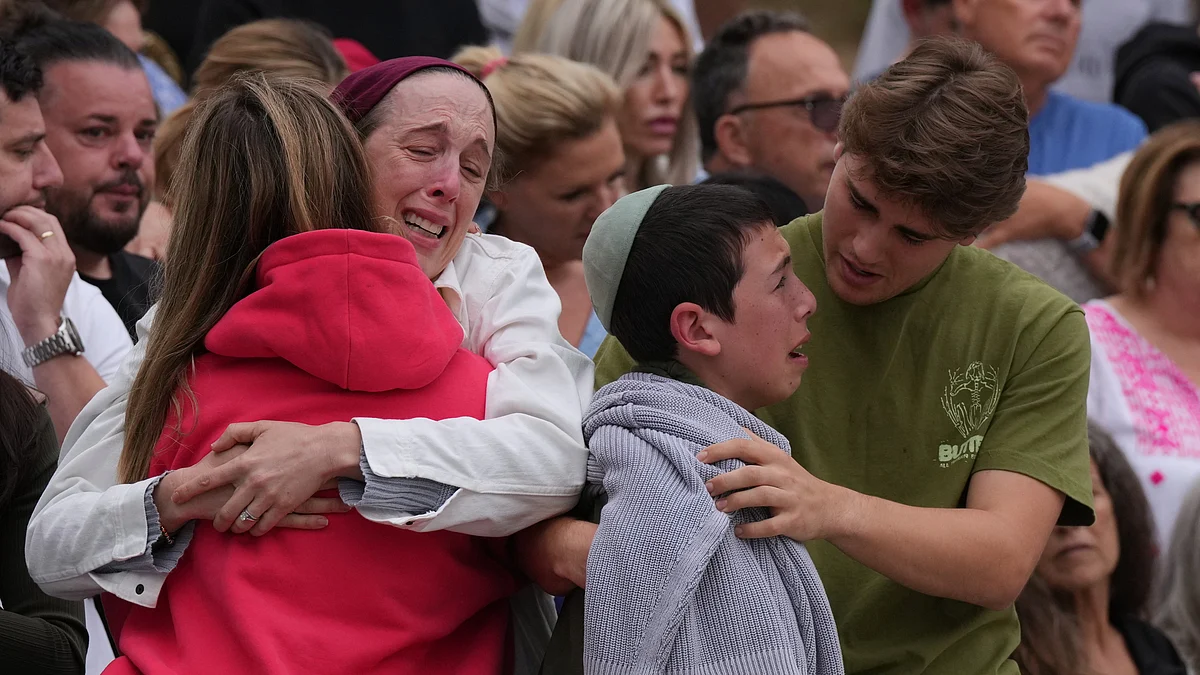 Family members of a victim from Sunday's shooting mourn at a flower memorial.