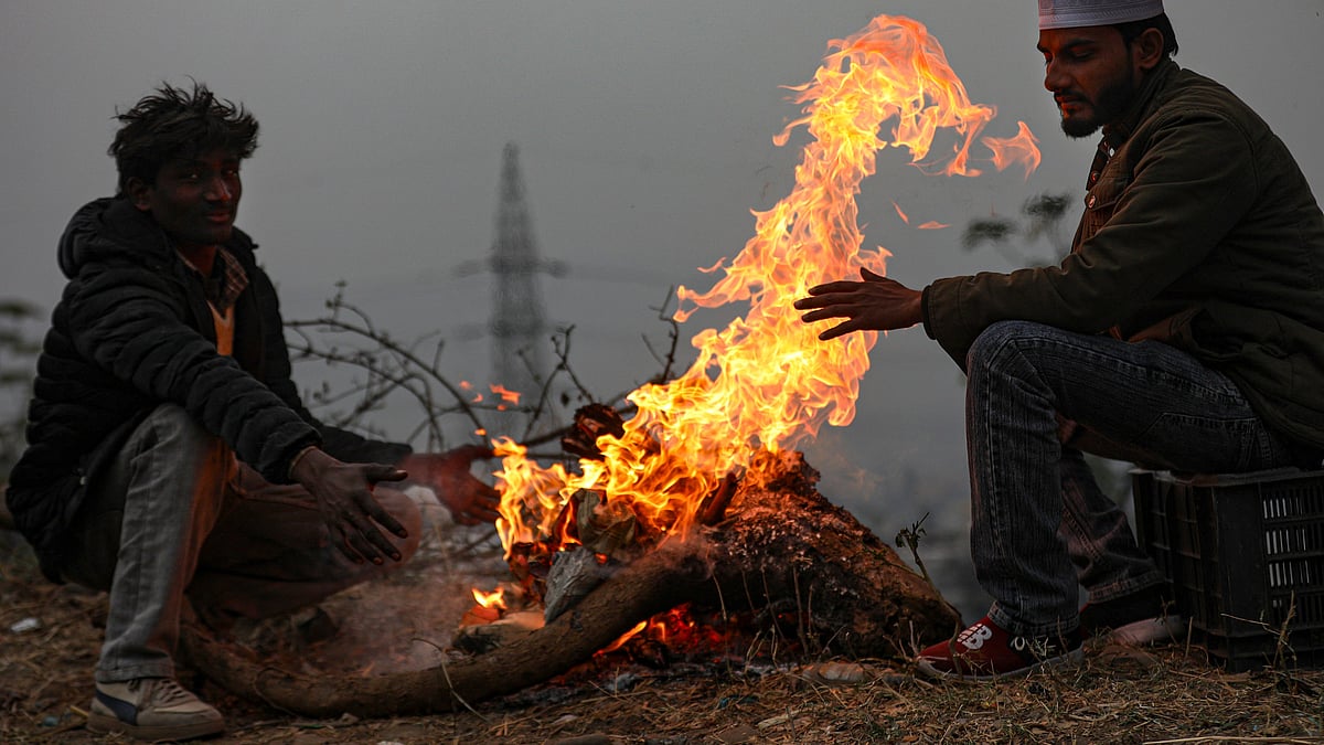 Beating the winter chill, people gather around a bonfire in Jammu.