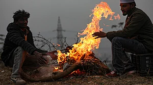 Beating the winter chill, people gather around a bonfire in Jammu.