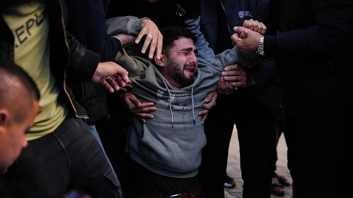 Mohammed al-Neder mourns family members killed by Israeli fire, at their funeral in Gaza City, 20 Dec