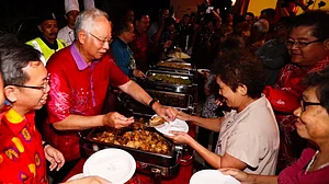 In this image from 2017, Razak serves food at an event to showcase 1MDB