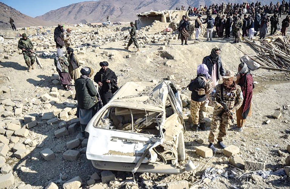 Taliban security personnel inspect a car destroyed in Pakistani airstrikes in Afghanistan’s Paktika province