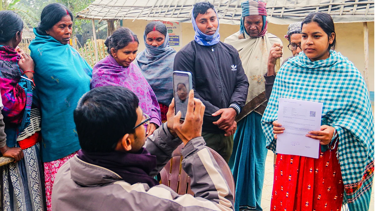A BLO photographs a voter after handing over a hearing notice, in Dakshin Dinajpur, West Bengal.