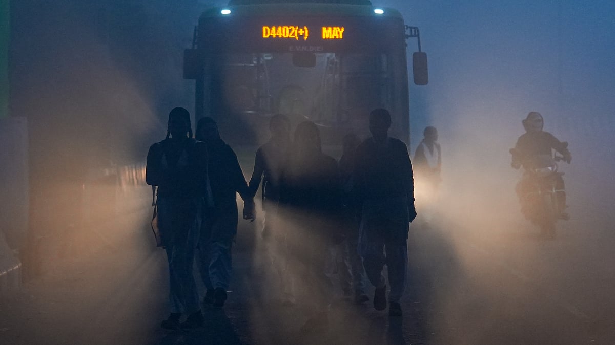 Students make their way to school through dense winter fog in New Delhi on 29 December.
