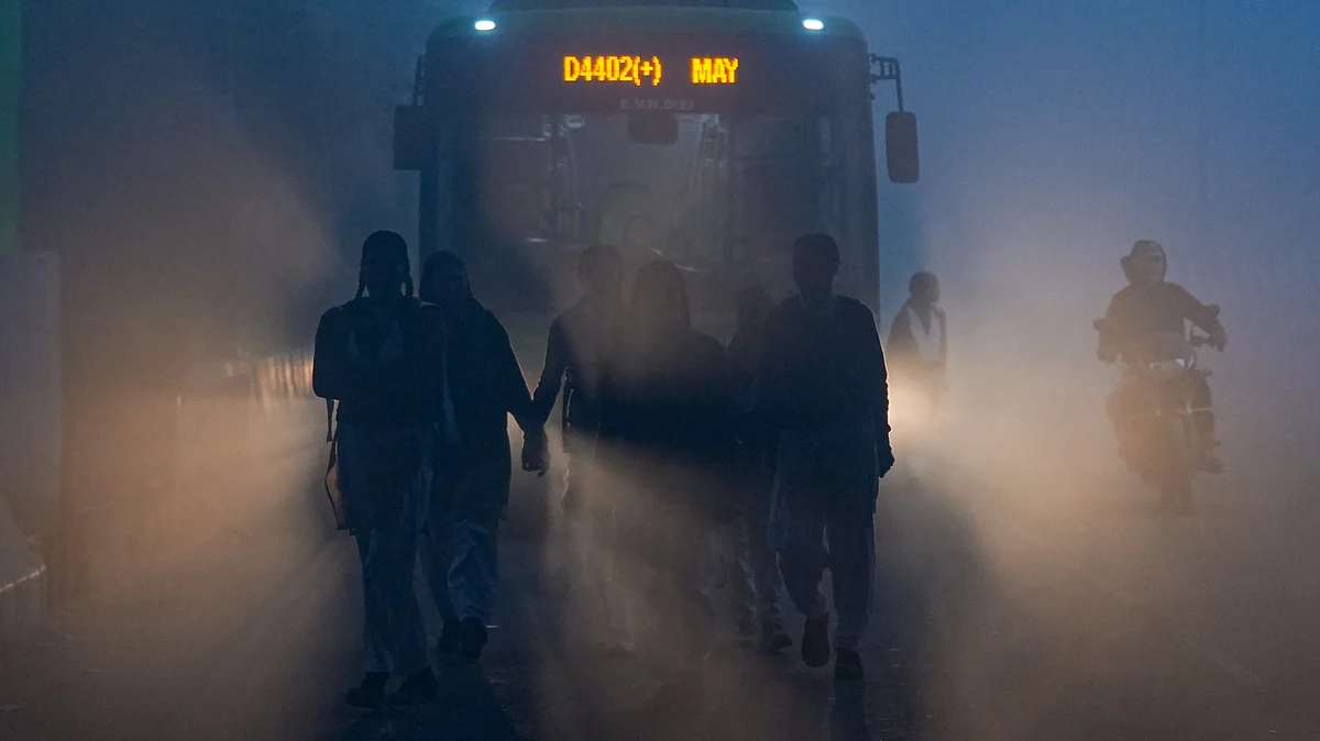 Students make their way to school through dense winter fog in New Delhi on 29 December.