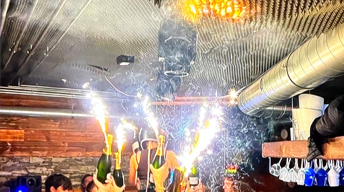 Revellers popping open champagne bottles as the fire starts at the nightclub