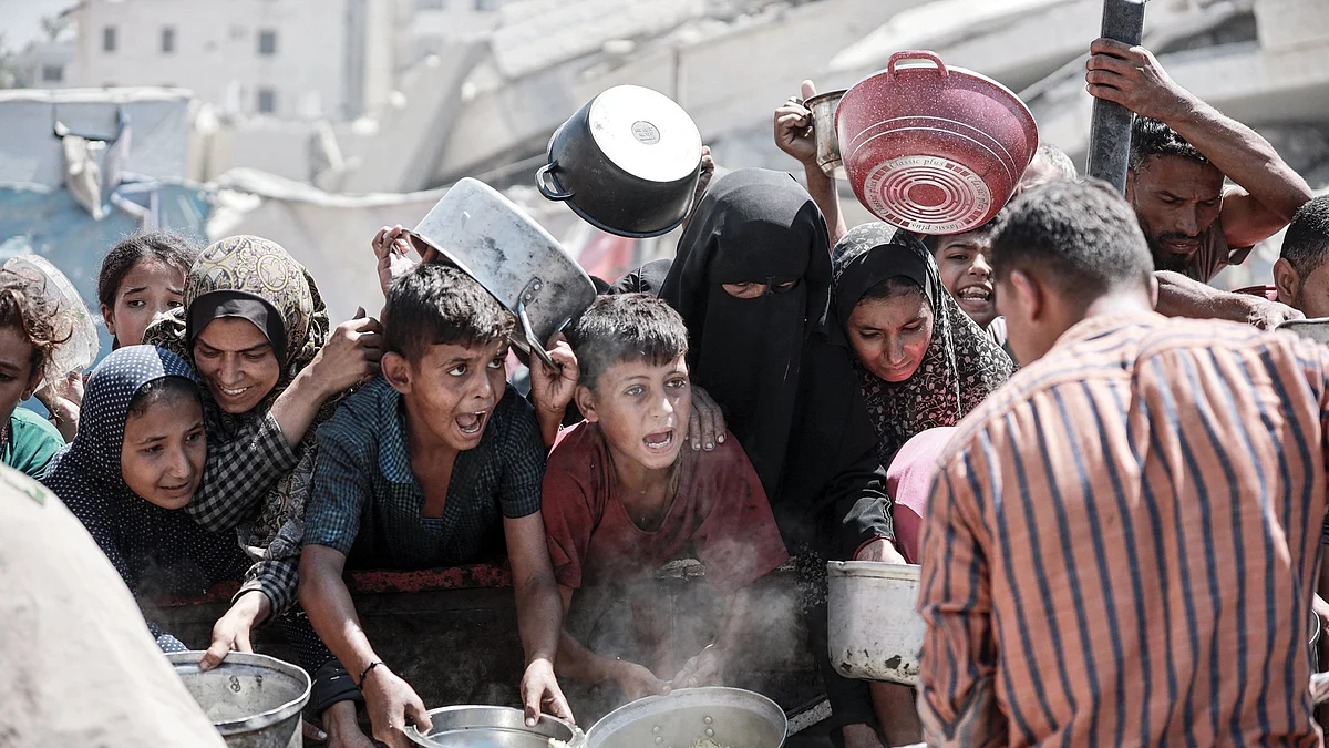 File photo of starving Palestinians wait for food at an aid distribution point in Gaza.
