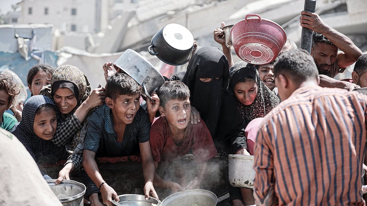 File photo of starving Palestinians wait for food at an aid distribution point in Gaza.