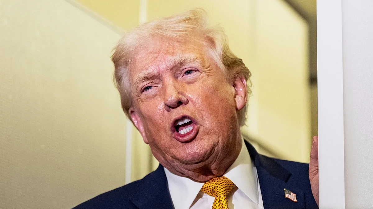 US President Donald Trump speaks to reporters aboard Air Force One.