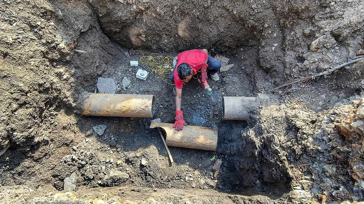 A civic worker during restoration of Narmada water pipelines in Indore.