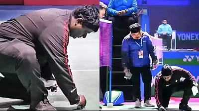 A match official cleans up the court after bird droppings stopped H.S. Prannoy's match