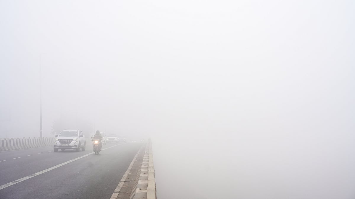 Commuters navigate dense fog on a cold winter morning in New Delhi.