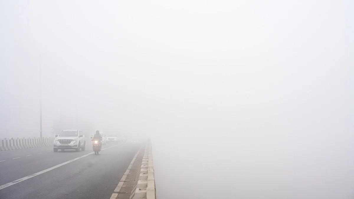Commuters navigate dense fog on a cold winter morning in New Delhi.