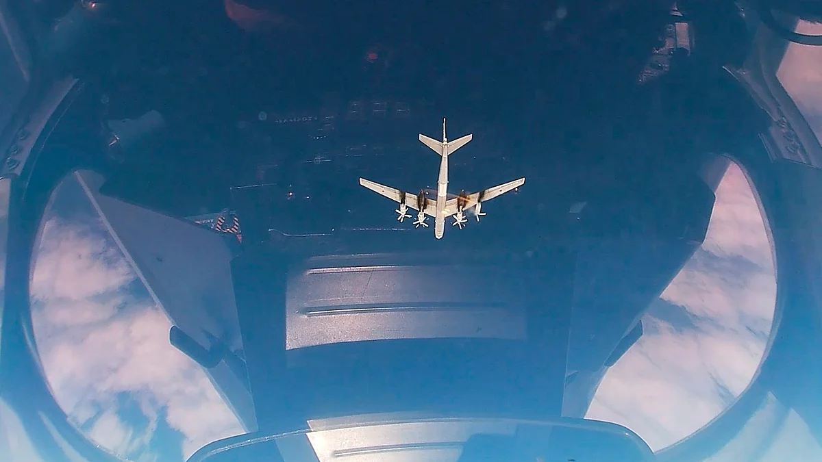 A Russian Tu-95 strategic bomber seen through the cockpit dome during a patrol mission.