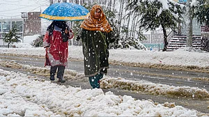 Residents navigate through fresh snowfall in Srinagar