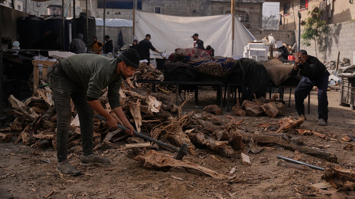 Palestinians gather firewood to cook donated meals in Nuseirat, central Gaza.