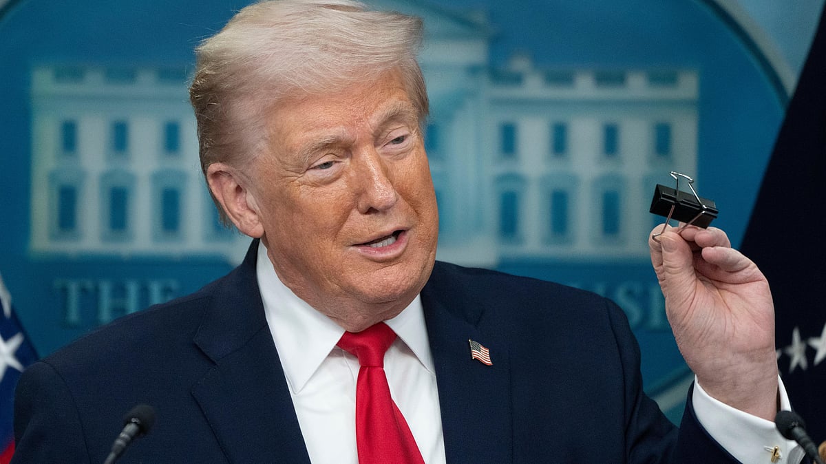 Donald Trump holds a binder clip as he speaks during a press briefing at the White House.
