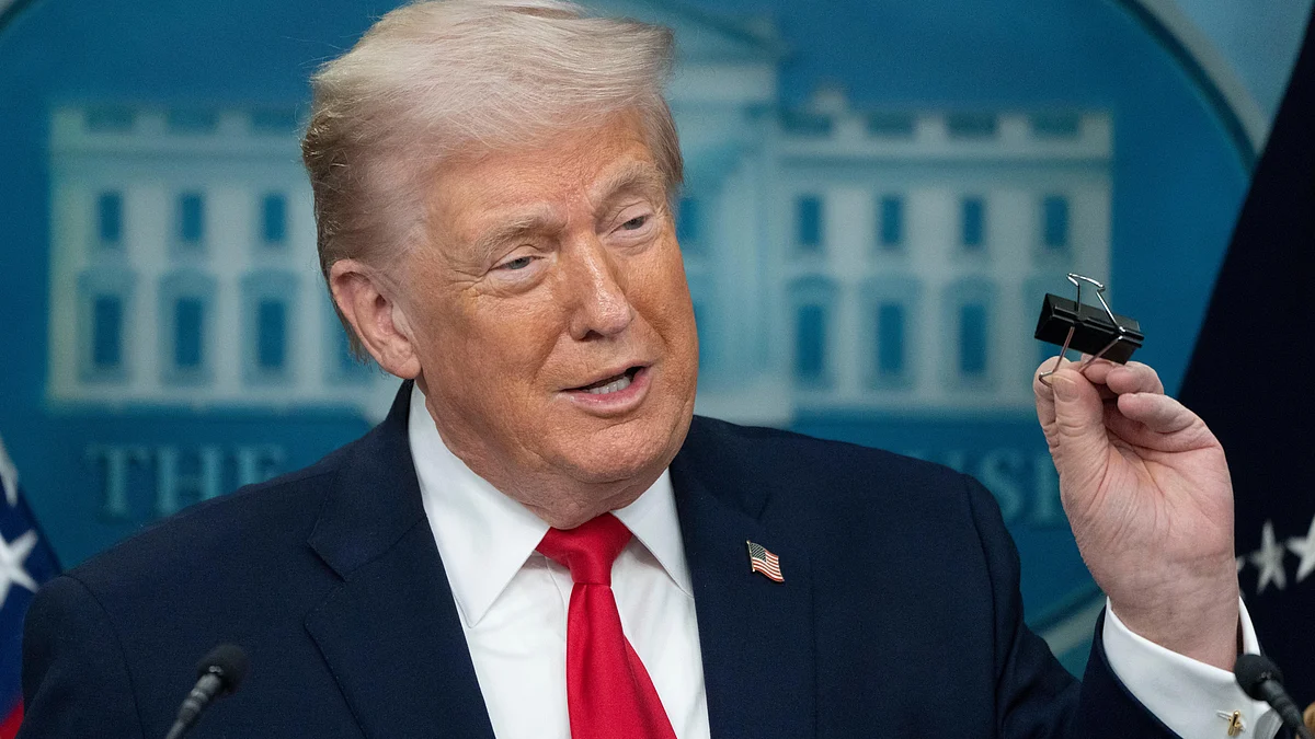 Donald Trump holds a binder clip as he speaks during a press briefing at the White House.