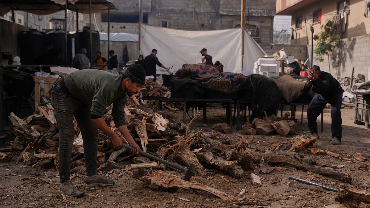 Palestinians gather firewood to cook donated food in Nuseirat, central Gaza.