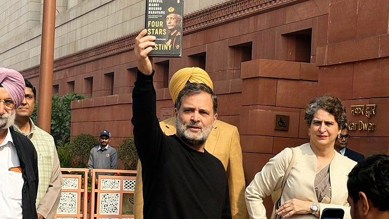 Rahul Gandhi holds up Gen. (retd) Naravane's book as Priyanka Gandhi Vadra looks on