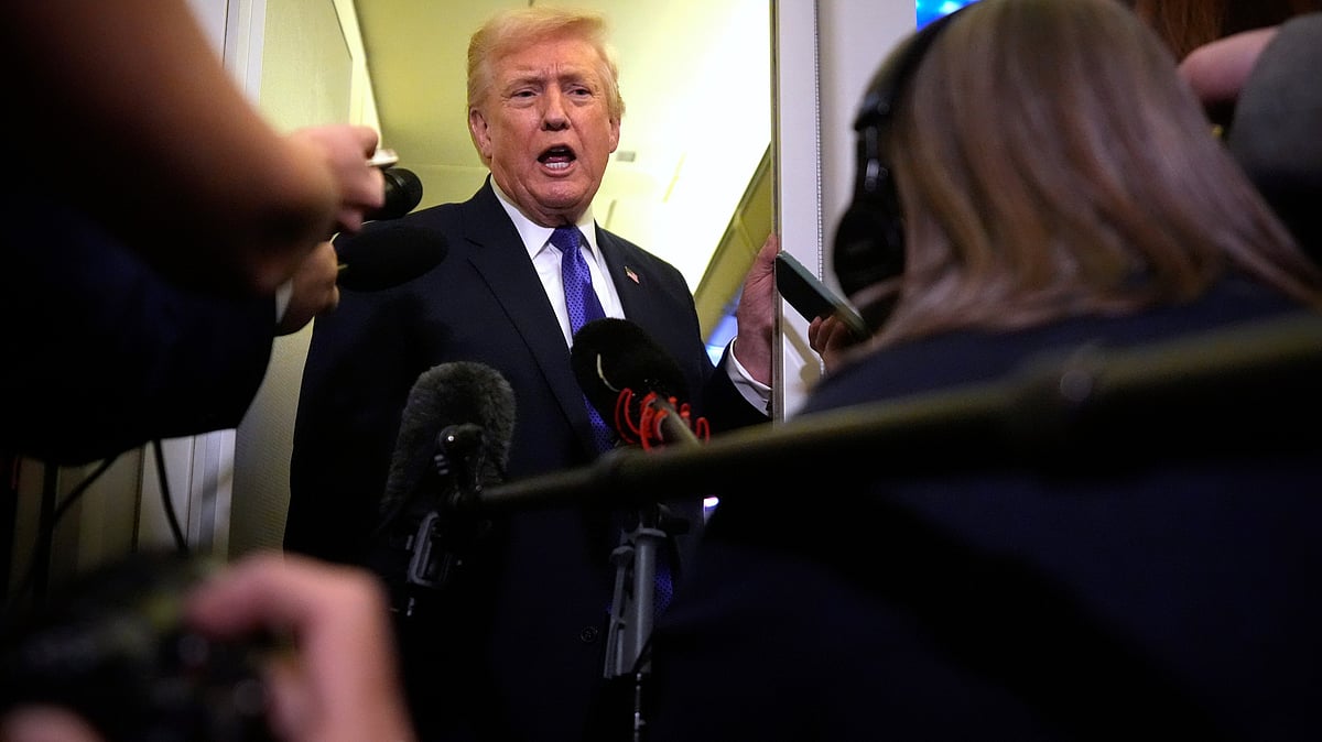 US President Donald Trump speaks to reporters aboard Air Force One.