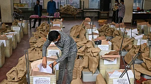 An official checks ballot boxes and voting papers ahead of polling day on 12 February