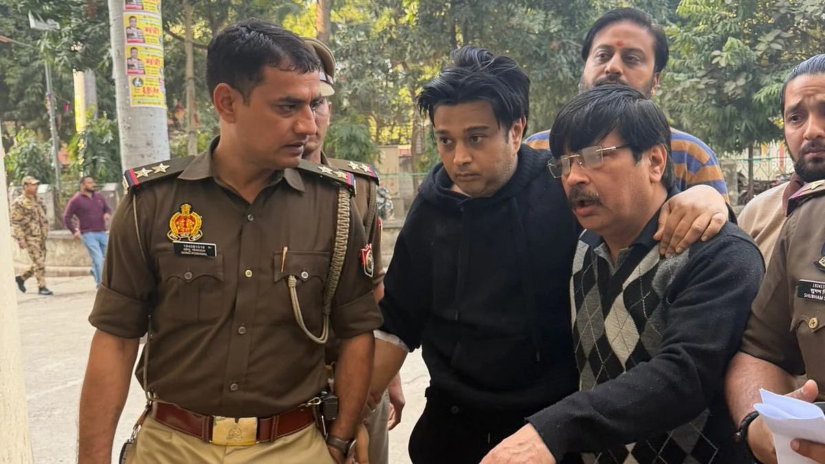 Shivam Mishra (center, in black) at the police station