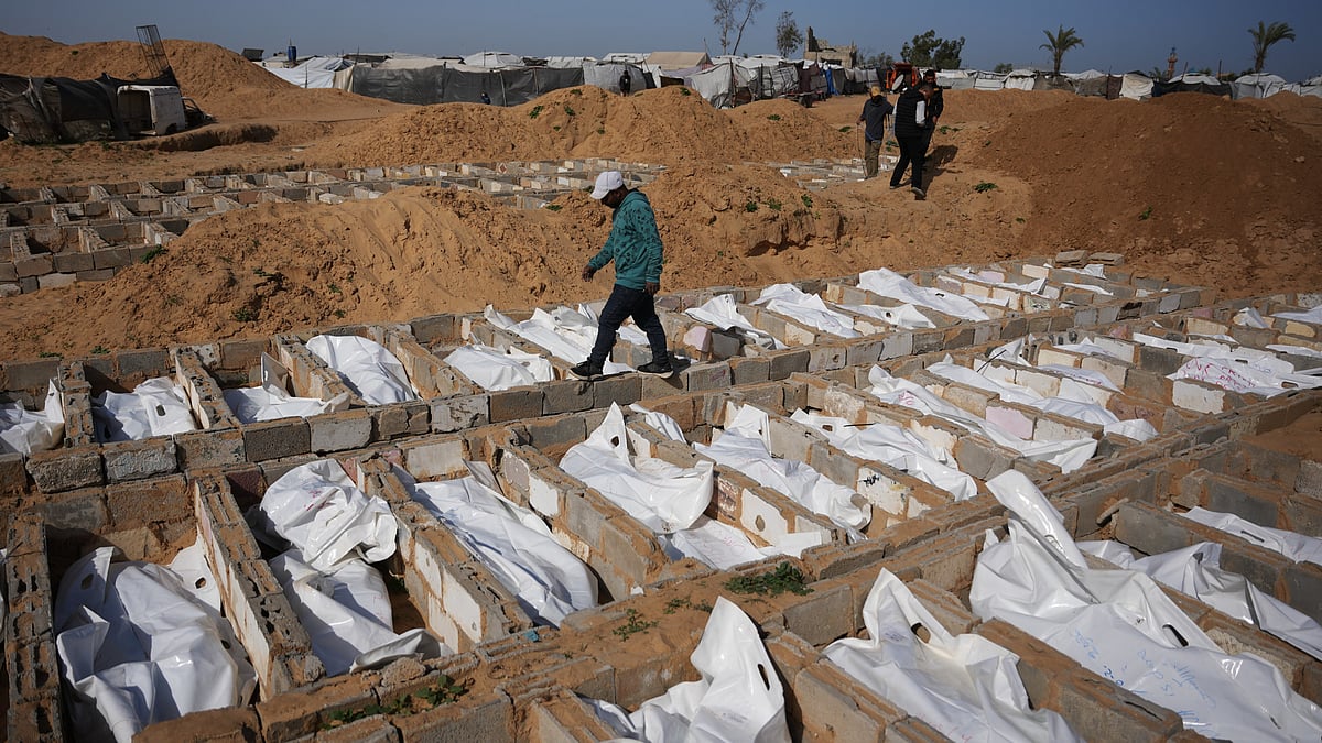 A man walks past freshly dug graves in Deir al-Balah, Gaza Strip.