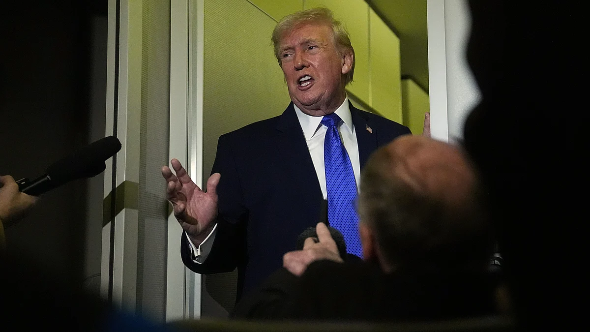 Donald Trump speaks to reporters aboard Air Force One during a flight.