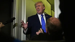 Donald Trump speaks to reporters aboard Air Force One during a flight.