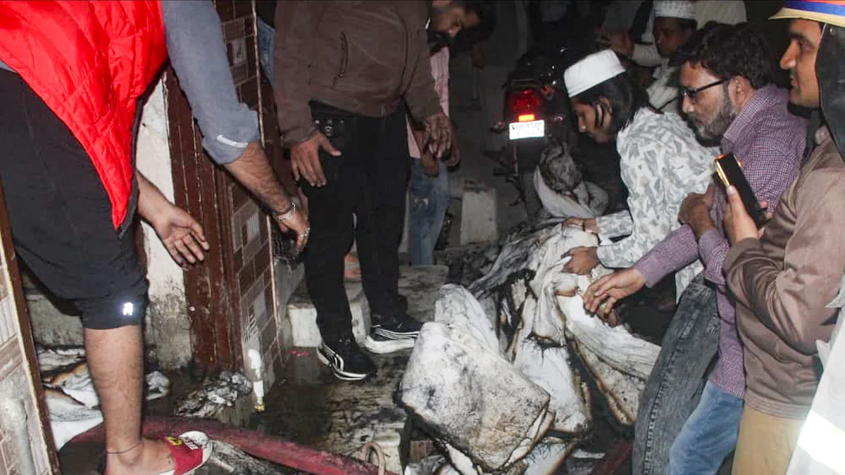 Locals survey the charred remains of a house after a devastating fire in Meerut.